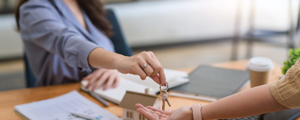 Home and real estate trading business. Real estate agent giving keys to house woman owner.